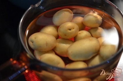 Выложить картофель в кастрюлю, залить водой и поставить на 15-20 мин. Снять с плиты. Дать остыть и разрезать на пополам.