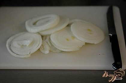 Порезать луковицу кольцами. Выложить на дно жаропрочного блюда или противень.