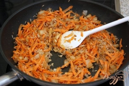 Спассеровать на растительном масле  лук и морковь, затем добавить рис и прожарить всё вместе.