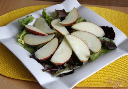 Выложить на тарелку микс салатных листьев, сверху - яблоко, порезанное тонкими дольками.