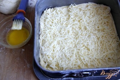 Второй слой теста сразу же выложить поверх первого, после сливочного масла, опять смазать маслом и посыпать натёртым сыром.