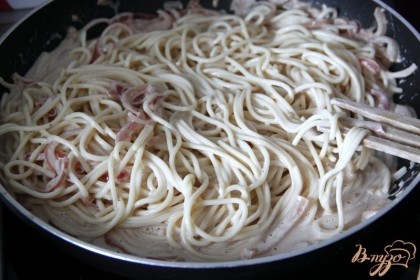 Выложить горячие спагетти в соус, перемешать. Если нужно добавить немного воды от варки спагетти.