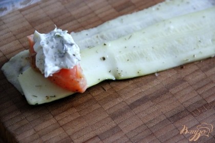На кабачковые ленты (можно брать по 2 внахлёст или по 1, если широкие)выложить кусочек лосося, сверху - 0,5ч.л. сливочного сыра с зеленью.