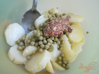 В салатнике смешать картофель и горсть зеленого горошка. Полить оливковым маслом и добавить горчицу. Хорошо размешать.