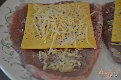 Поверх стейков выложить сыр пластинками, затем сыр Пармезан. Посыпать чесночной и луковой специей. Нет в продаже этих специй используйте натуральный лук и чеснок, мелко покрошив.