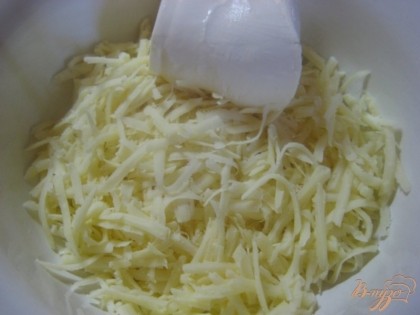 Сыр натереть на крупной терке, положить в миску, туда же сметану выложить.