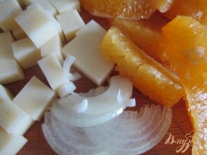 Сыр нарезать кубиками, апельсин на дольки без белых перепонок, немного репчатого лука.