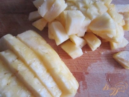 Половинку ананаса нарезать на кусочки.