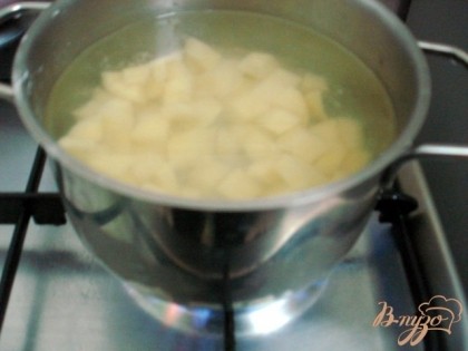Ставим на газ кастрюлю, наливаем 1,5 литра холодной воды, нарезаем картофель и начинаем его варить.