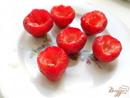 Срезать немного нижнюю часть ягоды (для того, чтобы клубника стояла), также срезать верхнюю часть и вынуть маленькой ложкой середину до половины ягоды.