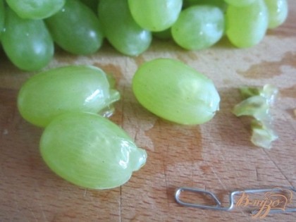 Из виноградин вынуть косточки. Сделать это просто , использовав скрепку .