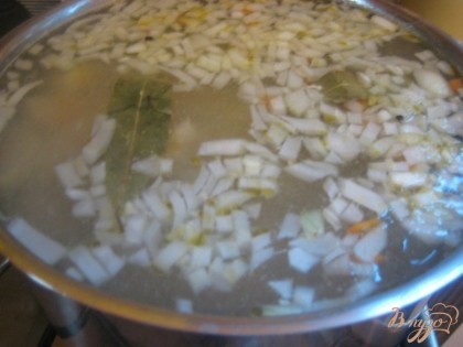 В кастрюлю к рыбе выложить овощи, перец и лавровый лист. Варить до готовности картофеля.