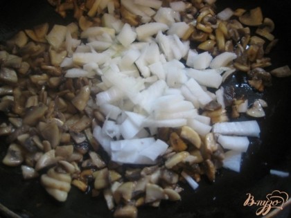 Лук очистить, вымыть и нарезать. Как только грибы станут слегка золотистыми, выложить лук на сковороду.