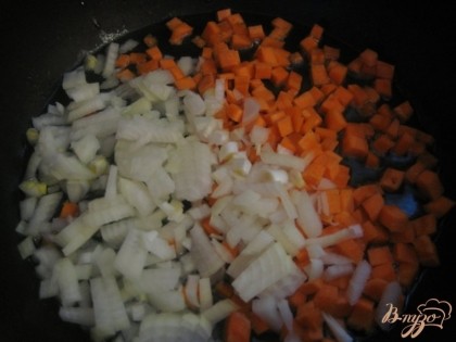 Лук и морковь очистить, вымыть, нарезать небольшими кубиками. В сковороду налить растительное масло и хорошо разогреть. Выложить овощи.