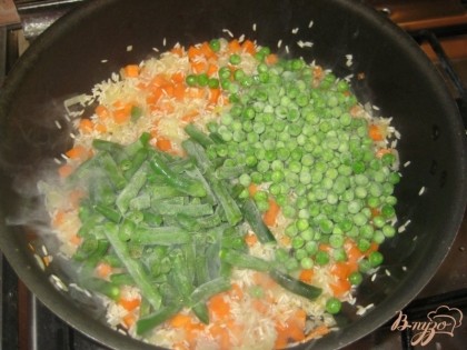 Затем выложить в сковороду горошек и фасоль. Причем использовать можно как замороженные овощи, так и свежие. Посолите. Накройте крышкой.