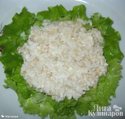 Рис заправить майонезом, слегка поперчить и выложить на листья салата