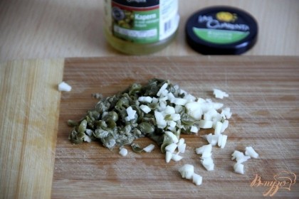 Мелко нарезать каперсы и чеснок. Каперсы можно заменить на кусочек солёного огурца или маслины.