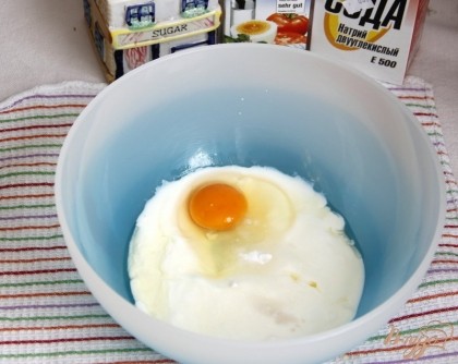 В кисломолочные продукты добавить яйцо, соду соль, сахар, соль, перемешать до однородности