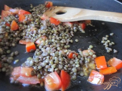 На сковороде на оливковом масле немного припустить кусочки томата и отваренную чечевицу.