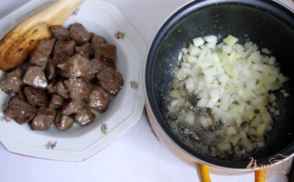 Мясо выложить на тарелку, накрыть фольгой, а в оставшемся жиру пассеровать мелконарезанный лук до прозрачности
