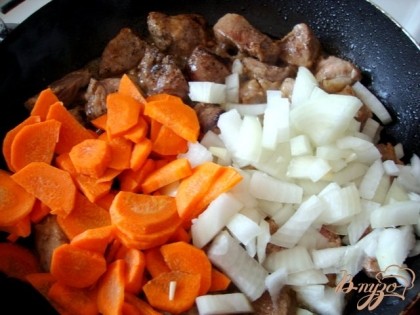 Лук и морковь добавляем к мясу. Помешивая, обжариваем до готовности, до десяти минут.