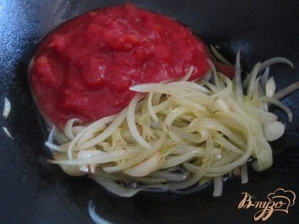 В сковороде на оливковом масле поджарить репчатый лук и чеснок в течении 5-7 мин.Затем добавить консервированные томаты. Перемешать.