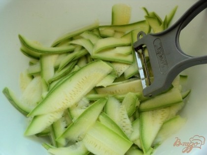 Молодой кабачок разрезать пополам и при помощи овощечистки нарезать тонкими ленточками.