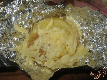 Когда картофель будет готов, открыть фольгу, быстренько добавить сыр и снова закрыть фольгу на 1 минуту. Так проделать с каждой картофелиной непосредственно перед подачей на стол, а не со всеми сразу.