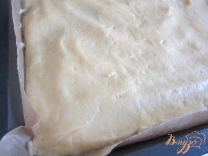 Тесто выложить на протвень с пекарской бумагой. Разровнять по всей поверхности так , чтобы слой не превышал 1 см.