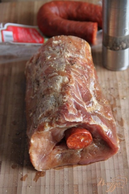 Отрезать кусок тонкой колбасы (можно любую сырокопчёную, у меня - чорризо), равный по длине  куску мяса и втолкнуть его в отверстие.