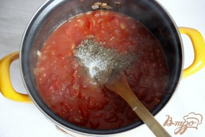 Добавить томаты в собственном соку (измельчённые), орегано, сахар, соль, перец. Варить соус 20-30 мин. под крышкой.