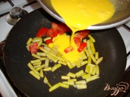 На разогретую с маслом сковороду выкладываем спаржу и помидоры чуть обжариваем и заливаем смесью яиц с молоком.