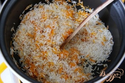 Очистить и натереть на мелкой тёрке морковь.Рис: Слегка обжарить морковь, добавить рис и обжарить его, хорошо мешая 2-3 минуты.