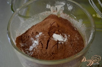 В отдельной емкости просеять муку,добавить какао,разрыхлитель и пищевую соду. Перемешать с масляной смесью.