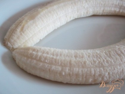 Бананы почистить от кожуры и разрезать вдоль.Уложить по десертным тарелкам , как видно на фото.