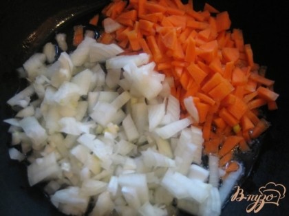 Лук и морковь нарезать небольшими кусочками, положить на заранее разогретую с маслом сковороду.