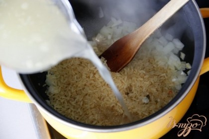 Добавить рис и обжарить несколько минут вместе. Добавить куриный бульон, чтобы он  покрыл рис на 1 палец сверху. Соль - по вкусу.