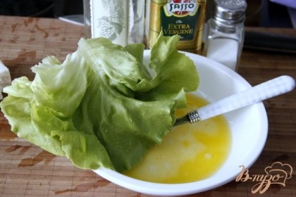 Симешать заправку: оливковое масло, соль, бальзамик и протянуть в ней сначала все листья салата, выложить их на дно тарелки.