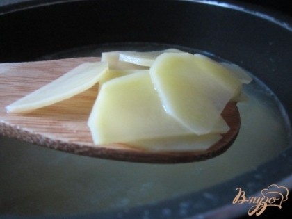 Картофель почистить , нарезать тонкими дольками и блоншировать в горячей воде 2 минуты.Воду слить.