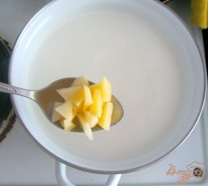 Когда молоко закипит, добавить в кастрюлю картофель. Помешивая, довести до кипения.