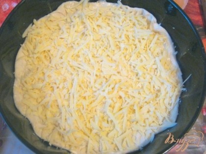 Посыпать нижний слой пирога тертым твердым сыром.