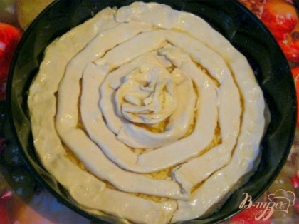 Выложить спиралью полоски теста с плавленным сыром поверх первого пласта теста с твердым сыром. Пирог смазать молоком и выпекать в разогретой духовке 15-20 минут.