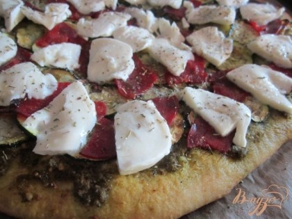 Когда пицца будет готова, по всей поверхности разложить кусочки сыра.Убрать в горячую, но уже выключенную духовку до расплавления сыра.