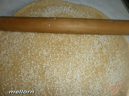 Из теста раскатать пласт толщиной 0.5 см. Сверху посыпать (щедро) кунжутом и сахаром. Слегка пройтись по тесту скалкой (вдавить).