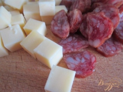 Сыр нарезать мелкими кубиками, колбаску тонкими колечками.