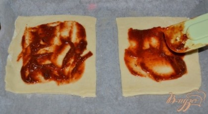 Раскатываем тесто , затем разрезаем на квадраты, должно выйти 6 квадратов. Каждый квадрат смазываем кетчупом или томатным соусом по центру,не задевая кончики краев.