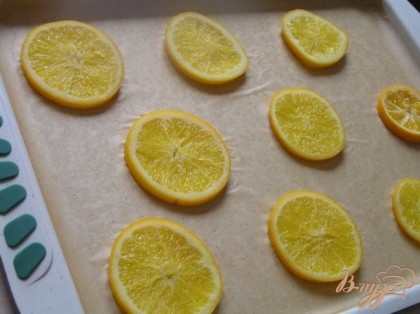 Подготовить противень (у меня 37х26х2см): застелить его бумагой для выпечки, смазать маслом, сверху выложить кружочки апельсинов.