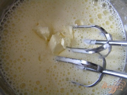 Приготовить бисквит. Желтки взбить в пену, добавить молоко и сливочное масло, продолжая взбивать.