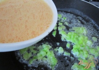 На сковороде растопить сливочное масло, выложить рубленные кусочки готовой  спаржи и вылить взбитые яйца.