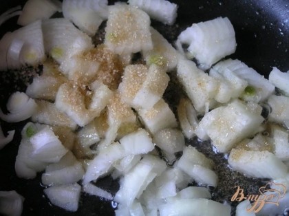 В ту же сковороду выложить мелко нарезанный лук, добавить сахар, готовить помешивая до карамелизации, выложить к яблокам.